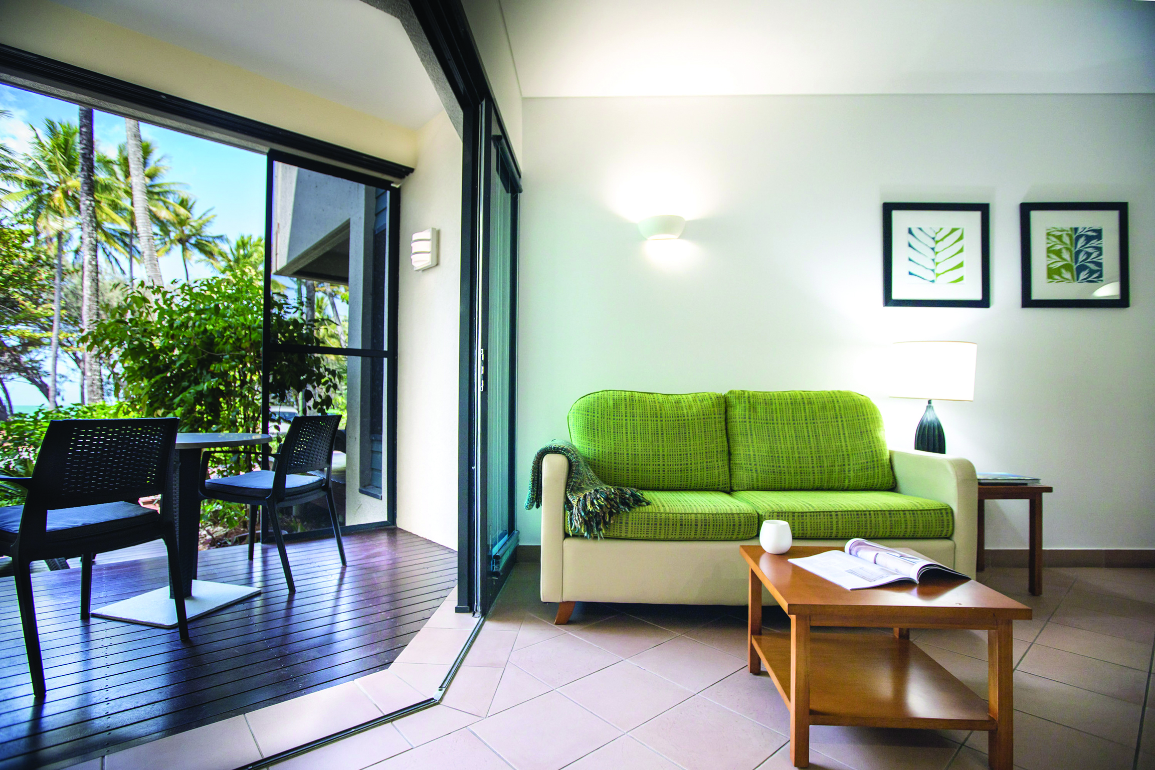 Port Douglas Peninsula Queensland ocean view lounge seating area with sofa and open door to decked terrace area