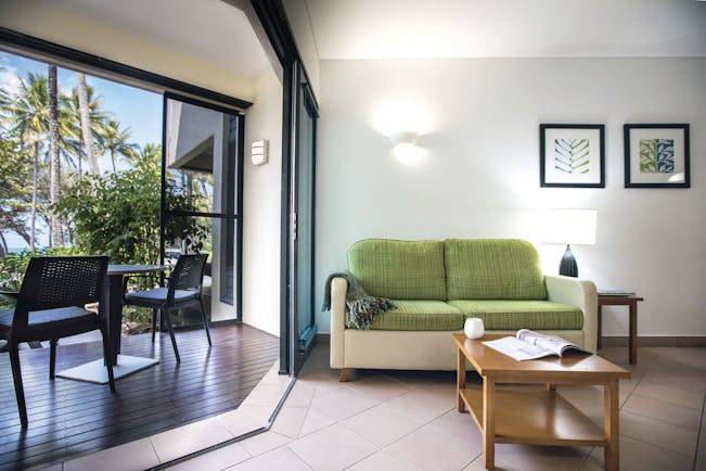 Port Douglas Peninsula Queensland ocean view lounge seating area with sofa and open door to decked terrace area
