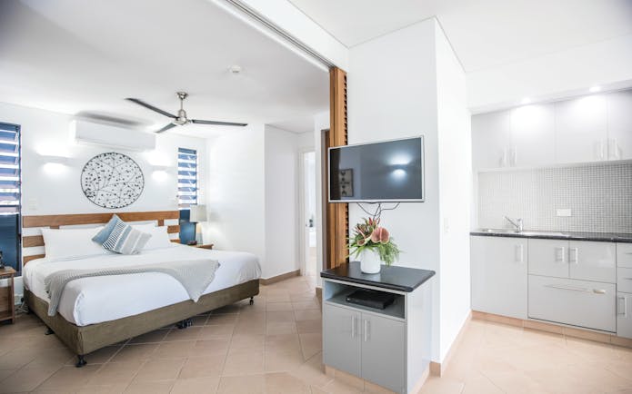 Port Douglas Peninsula Queensland suite with white kitchen and bedroom and television