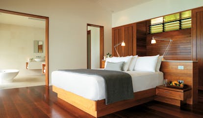 Qualia Hamilton Island Queensland Windward bedroom with wooden walls and floors and view of bathroom