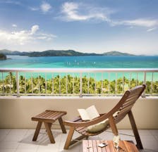Reef View balcony, wooden deck chair and footstall overlooking turquoise blue sea