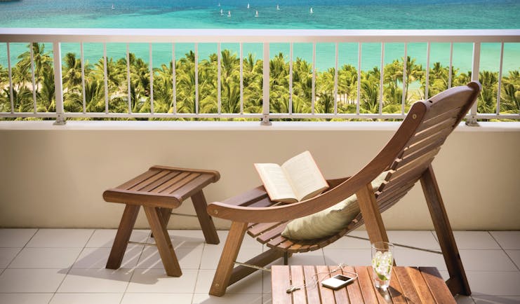 Reef View balcony, wooden deck chair and footstall overlooking turquoise blue sea