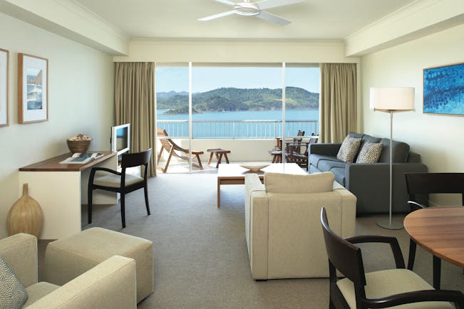 Reef View suite lounge, armchairs, desk, sofa, modern decor, balcony overlooking the sea