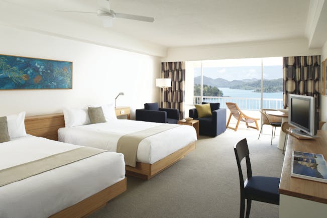 Reef View Twin guestroom, beds, armchairs, bright modern decor, balcony overlooking the sea