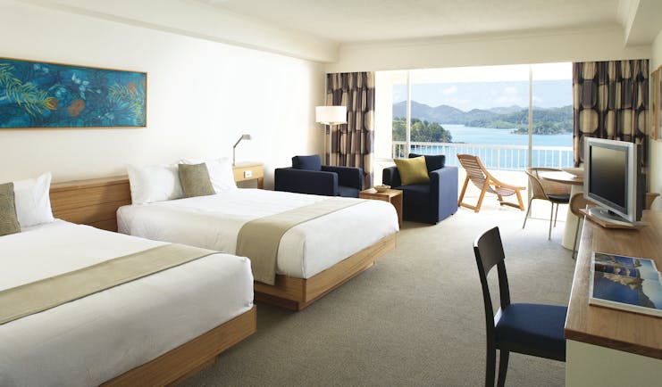 Reef View Twin guestroom, beds, armchairs, bright modern decor, balcony overlooking the sea