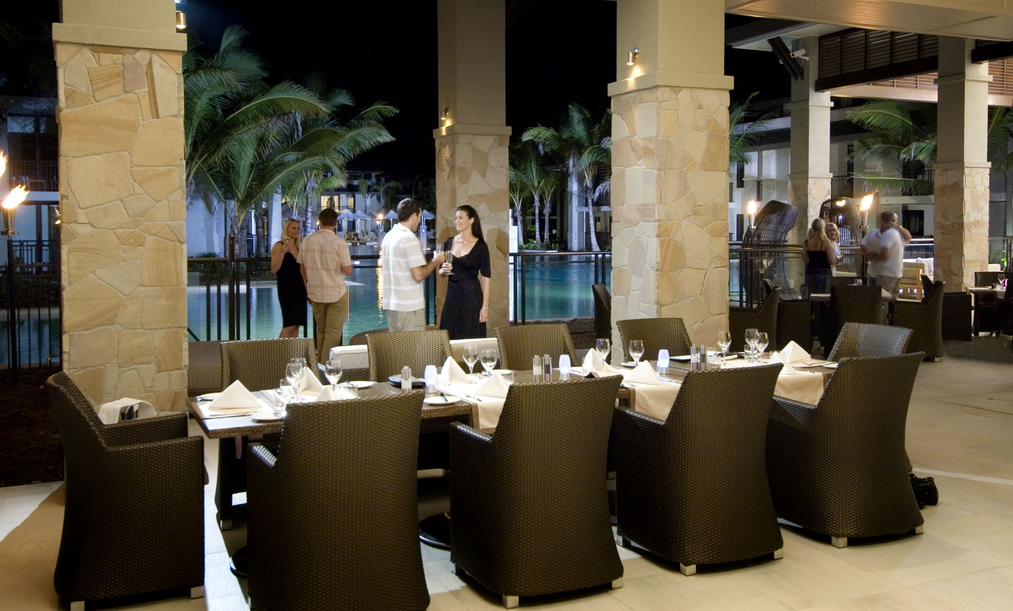 Sea Temple Queensland dining people enjoying drink in dining area near swimming pool