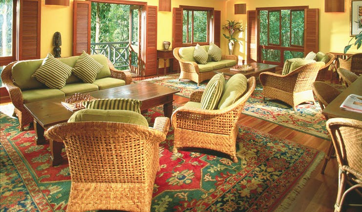 Silky Oaks Lodge Queensland lounge with wicker chairs and sofas and access to balcony