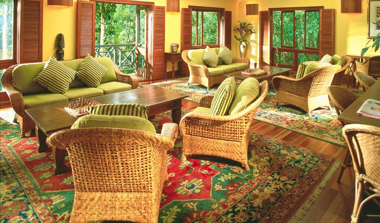 Silky Oaks Lodge Queensland lounge with wicker chairs and sofas and access to balcony
