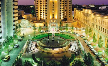 Intercontinental Adelaide view onto hotel at night with a brightly lit plaza below with reen trees lining the walkways