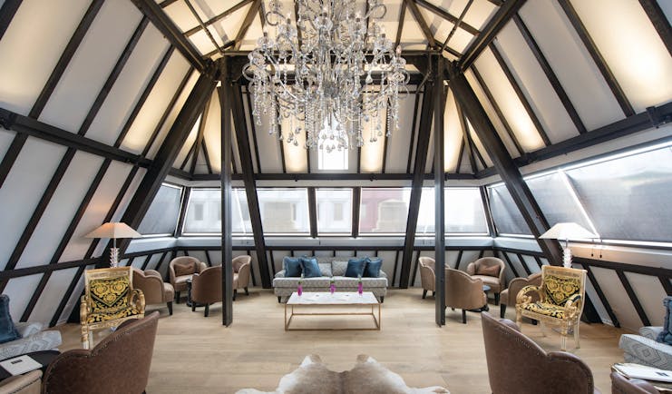 Bar with window pannelled ceiling and walls, large chandelier and seating areas