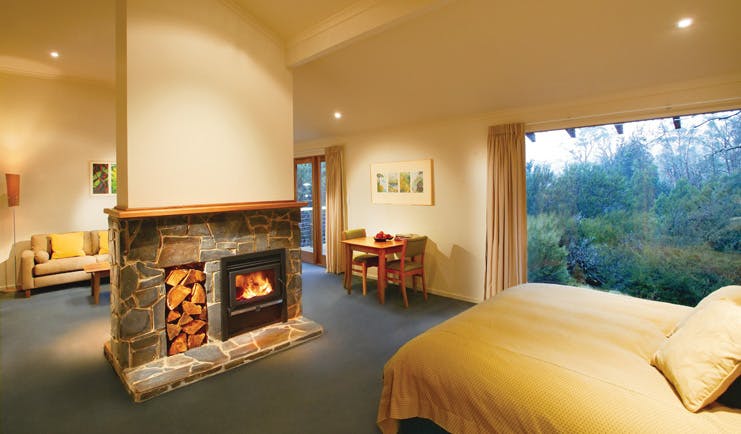 Cradle Mountain Lodge Tasmania bedroom view  fireplace sitting area and forest view