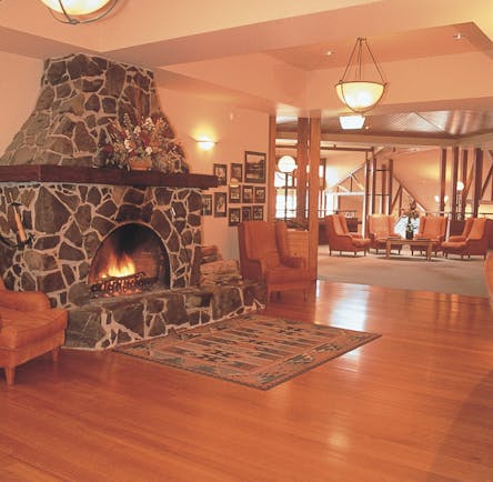 Freycinet lodge lounge area with stone open fire and wooden floors