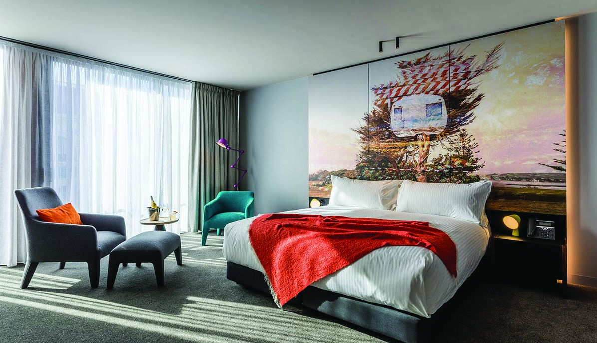 MACq01 double room, bed, armchair, modern decor with large painted mural wall