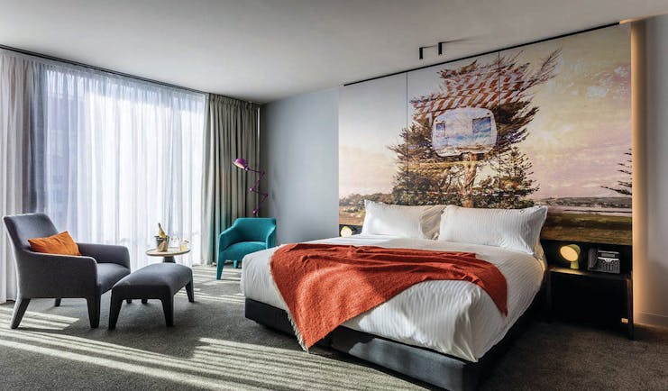 MACq01 double room, bed, armchair, modern decor with large painted mural wall