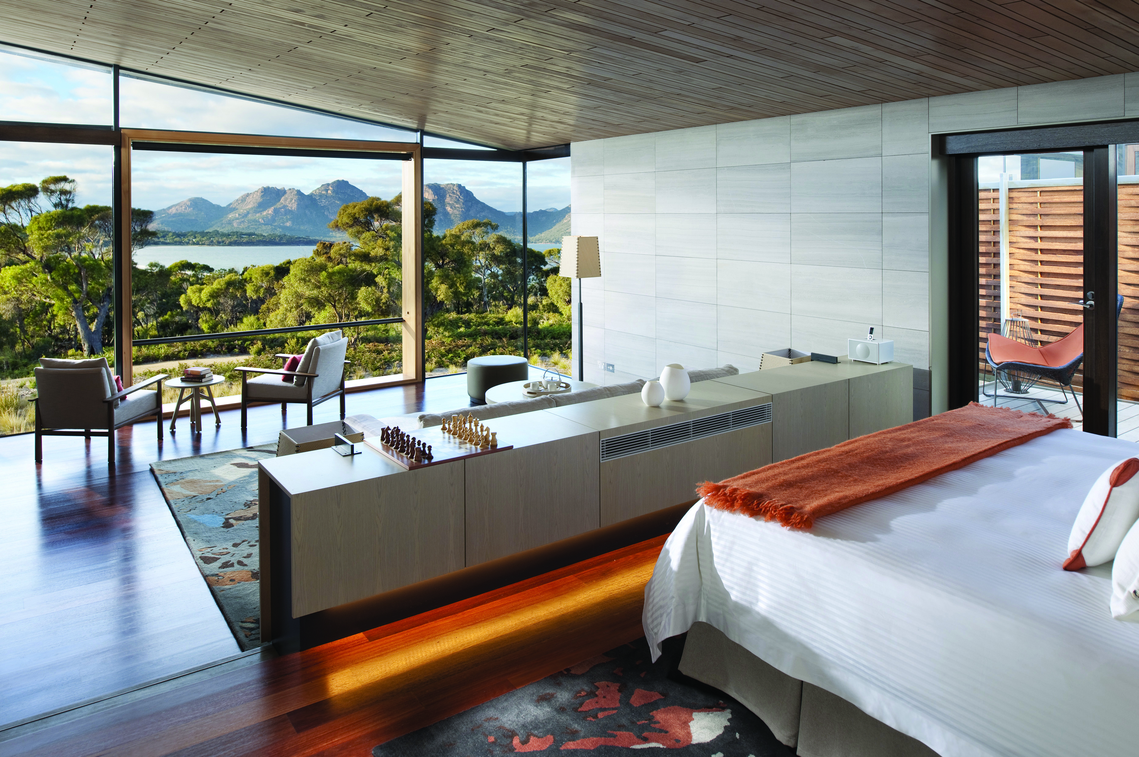 Saffire Freycinet Tasmania deluxe suite with floor to ceiling windows and seating area with mountain view