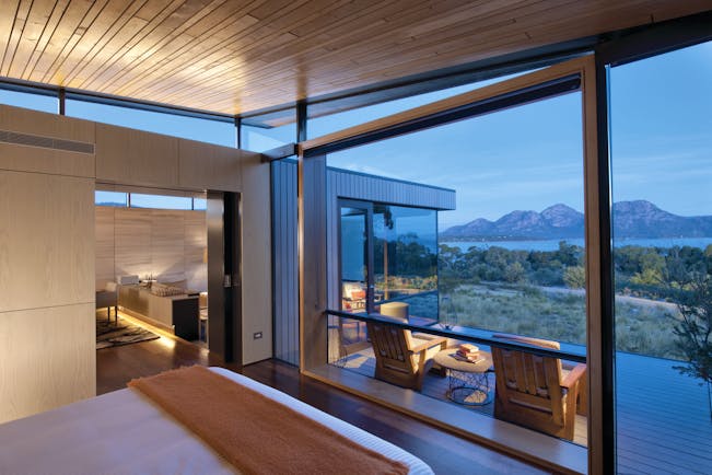 Saffire Freycinet Tasmania premium suite with large windows leading to deck with mountain and sea view