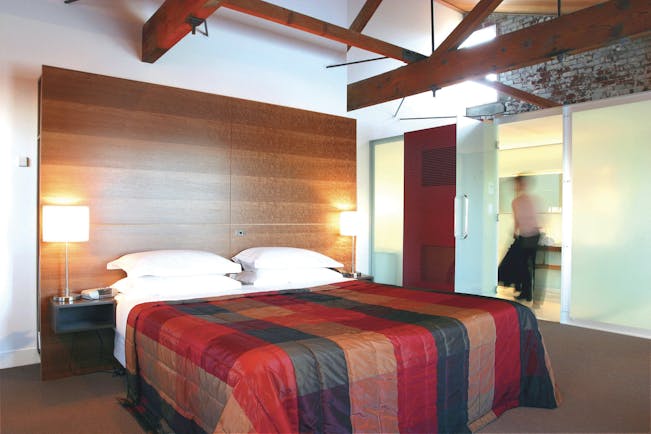 The Henry Jones Art Hotel Tasmania bedroom with exposed beams and stonework