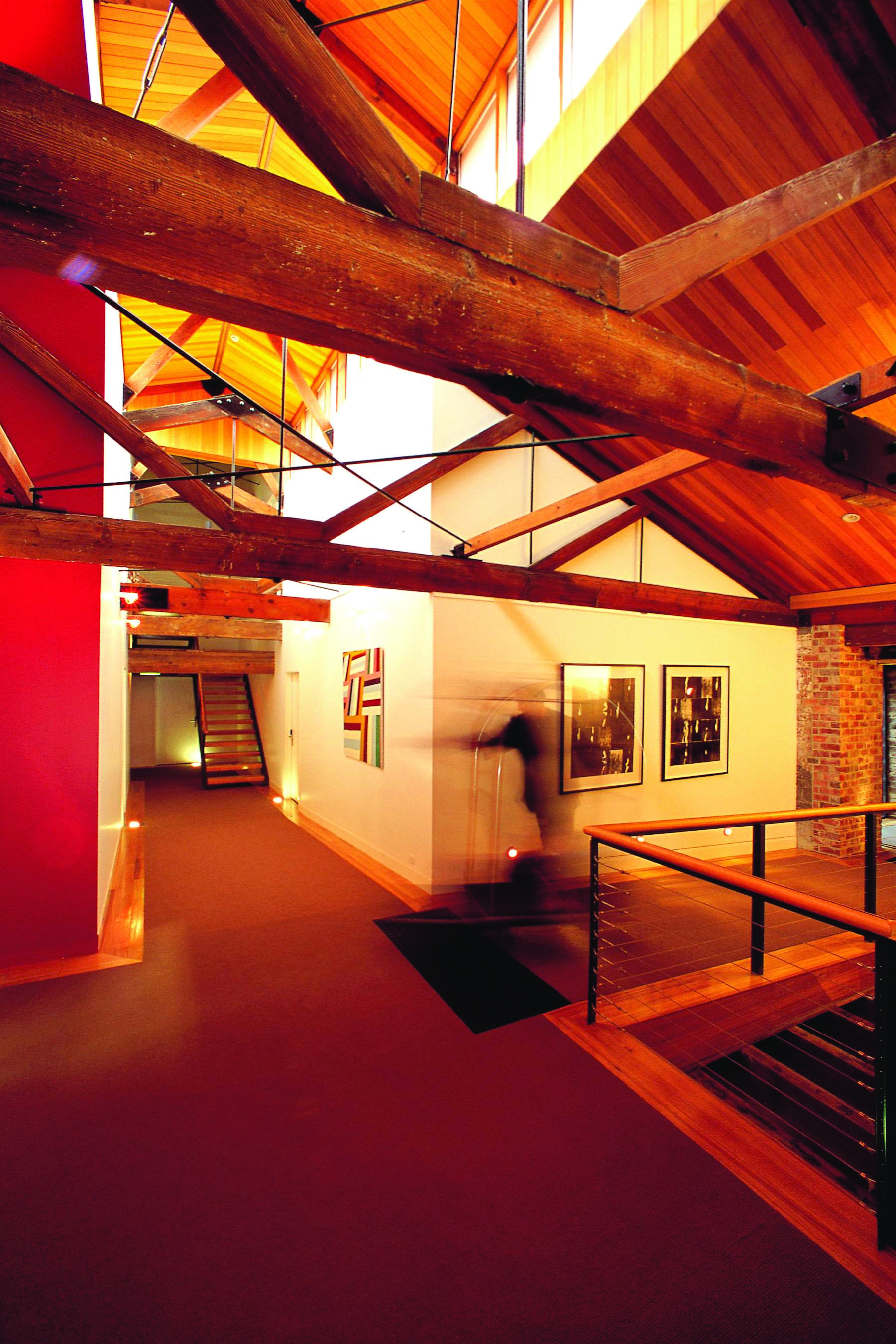 The Henry Jones Art Hotel Tasmania corridor with exposed beams and stonework and artwork on the walls
