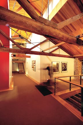 The Henry Jones Art Hotel Tasmania corridor with exposed beams and stonework and artwork on the walls