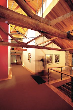 The Henry Jones Art Hotel Tasmania corridor with exposed beams and stonework and artwork on the walls