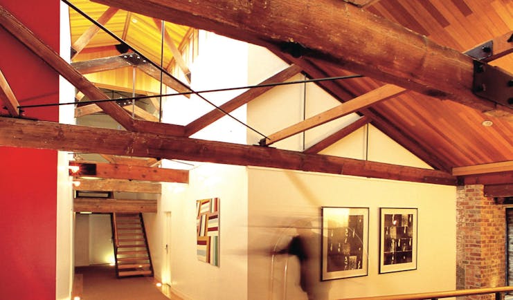 The Henry Jones Art Hotel Tasmania corridor with exposed beams and stonework and artwork on the walls