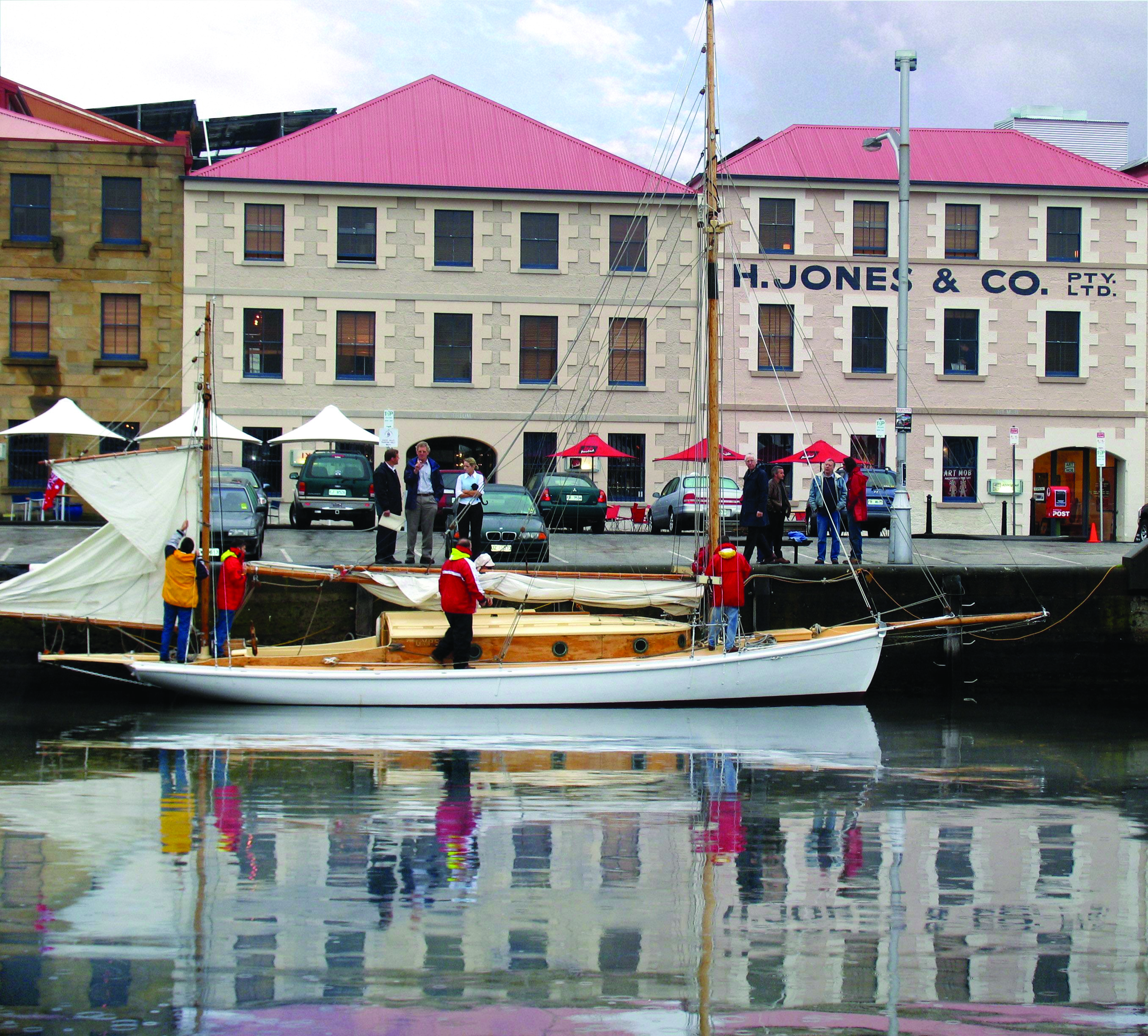 The Henry Jones Art Hotel Tasmania exterior large cream building overlooking a boat in a marina