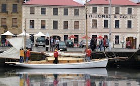 The Henry Jones Art Hotel Tasmania exterior large cream building overlooking a boat in a marina