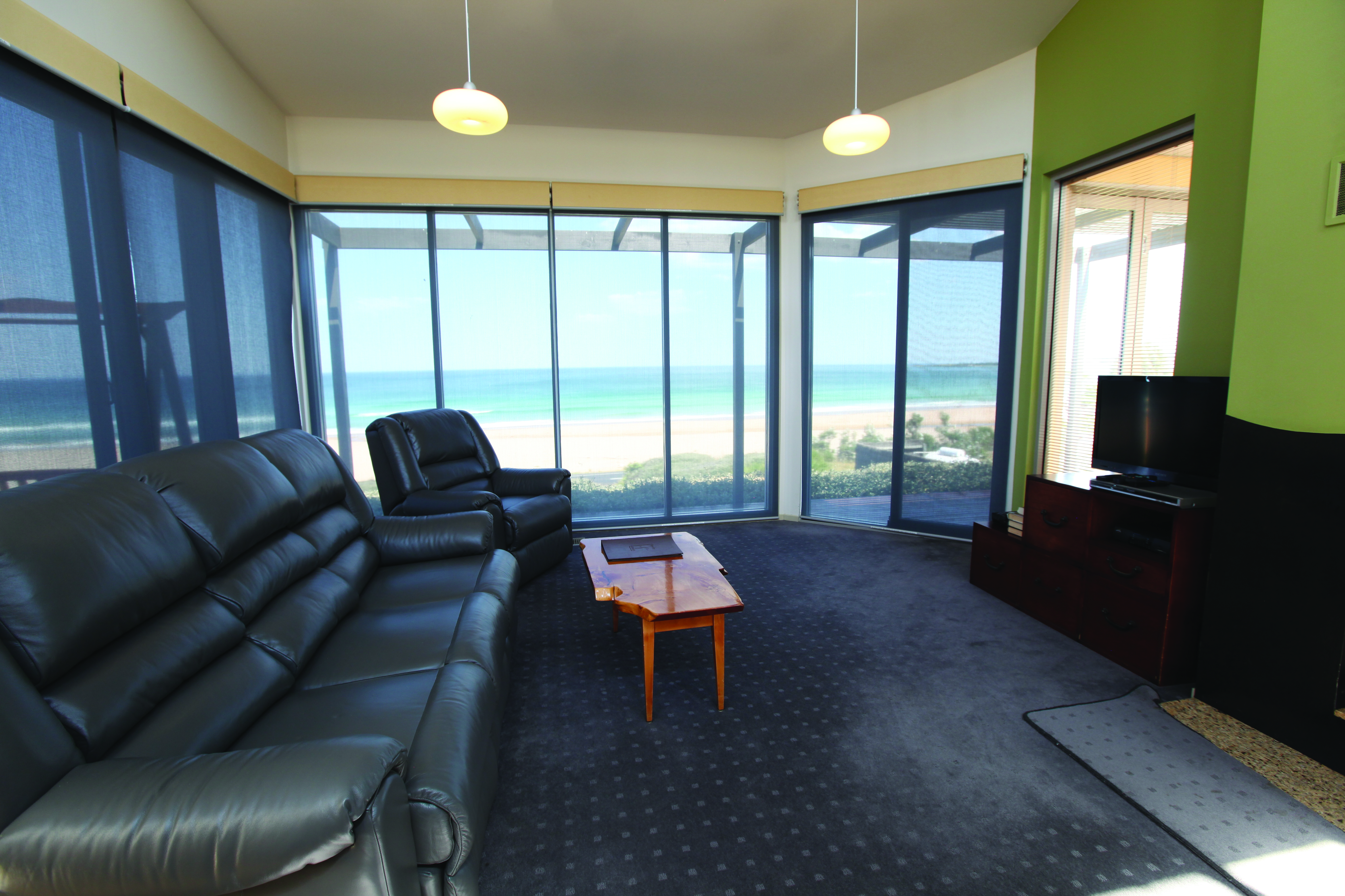 Chocolate Gannets Victoria and Melbourne lounge with large sofa floor to ceiling windows and beach view