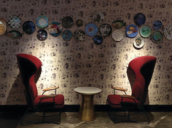 QT Melbourne Pascale bar, highbarked armchairs in red velvet, plates decorating wall