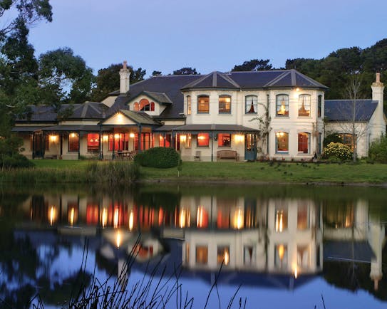Woodman Estate Victoria exterior large white building with grey roof and large windows overlooking a lake
