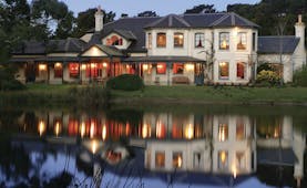 Woodman Estate Victoria exterior large white building with grey roof and large windows overlooking a lake