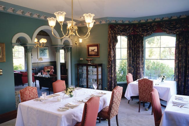 Woodman Estate Victoria formal dining room with arches chandeliers and draped curtains