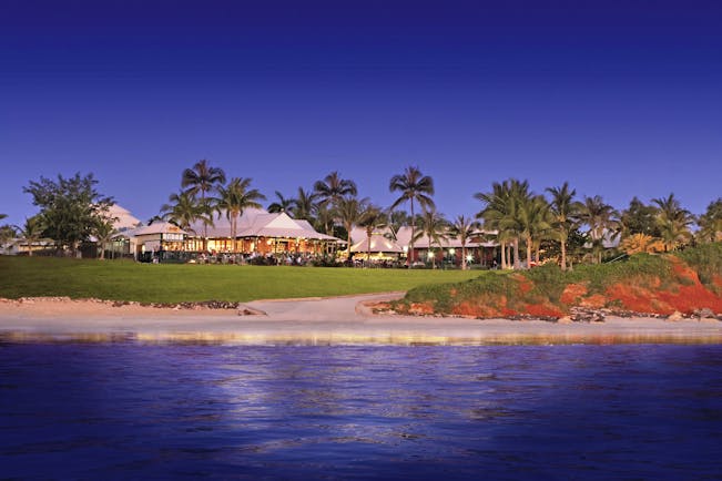 Cable Beach Club exterior shot from sea, hotel buildings, green lawns, palm trees, sand, sea