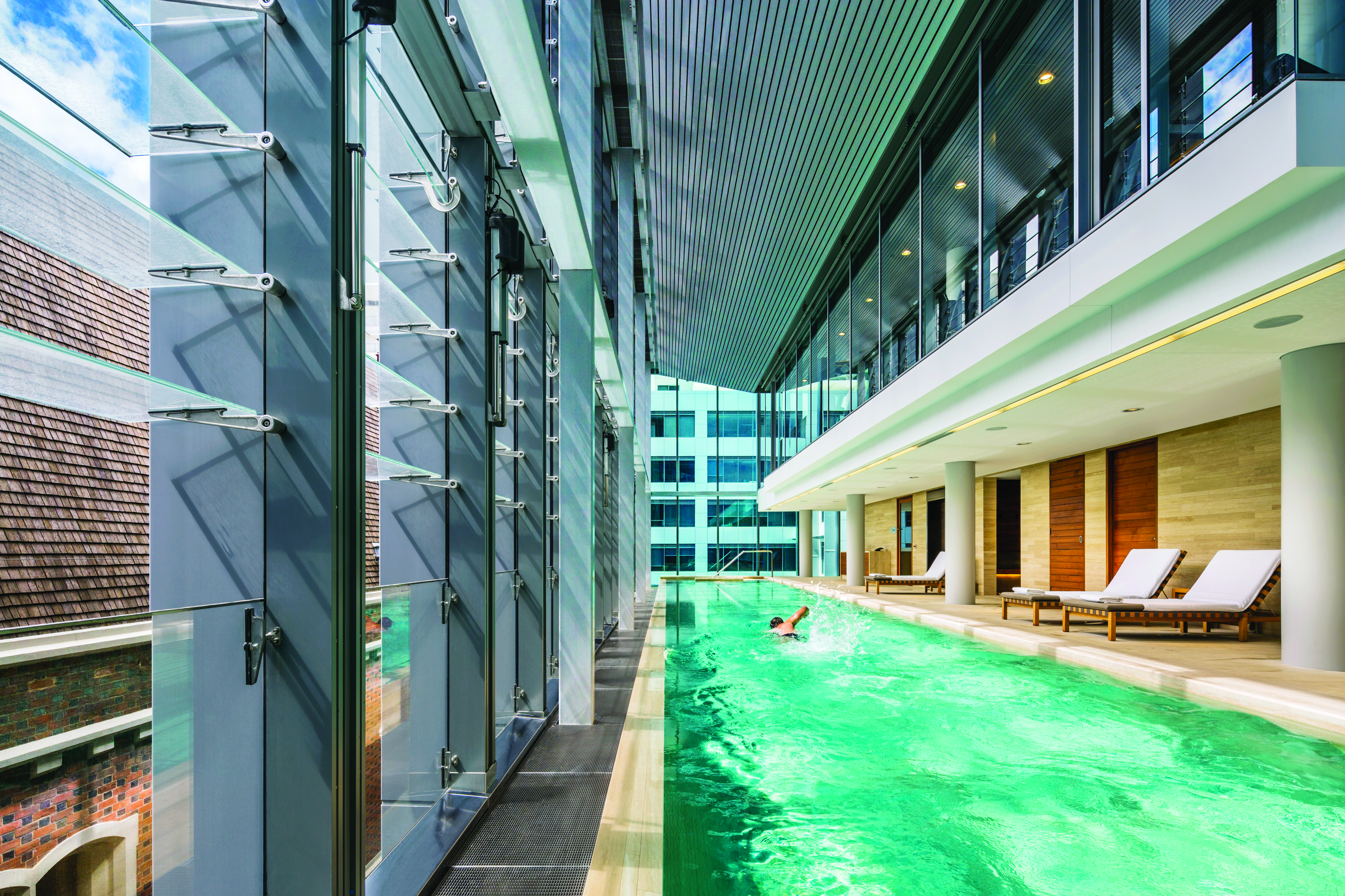 COMO The Treasury indoor pool, sun loungers, lap pool, man doing breast stroke