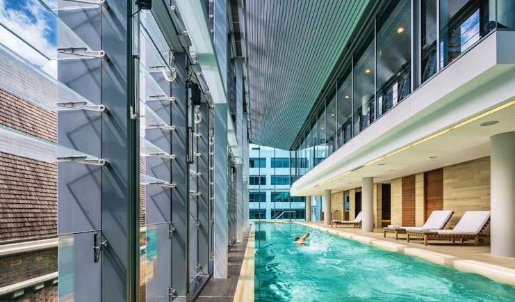 COMO The Treasury indoor pool, sun loungers, lap pool, man doing breast stroke