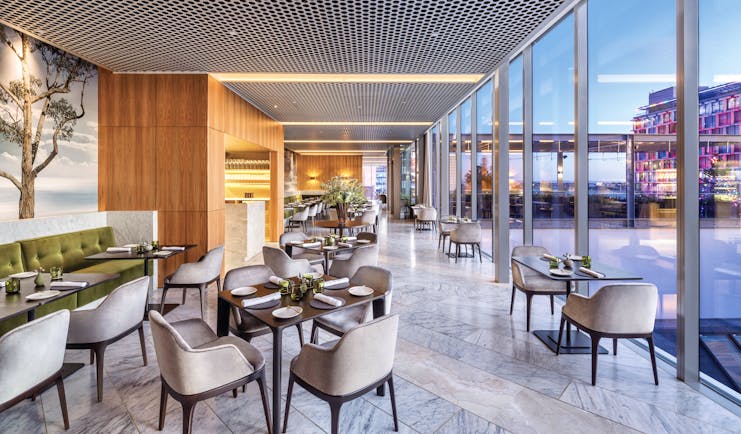 COMO the Treasury restaurant, indoor dining area with panoramic windows with cityscape views, velvet chairs, elegant decor