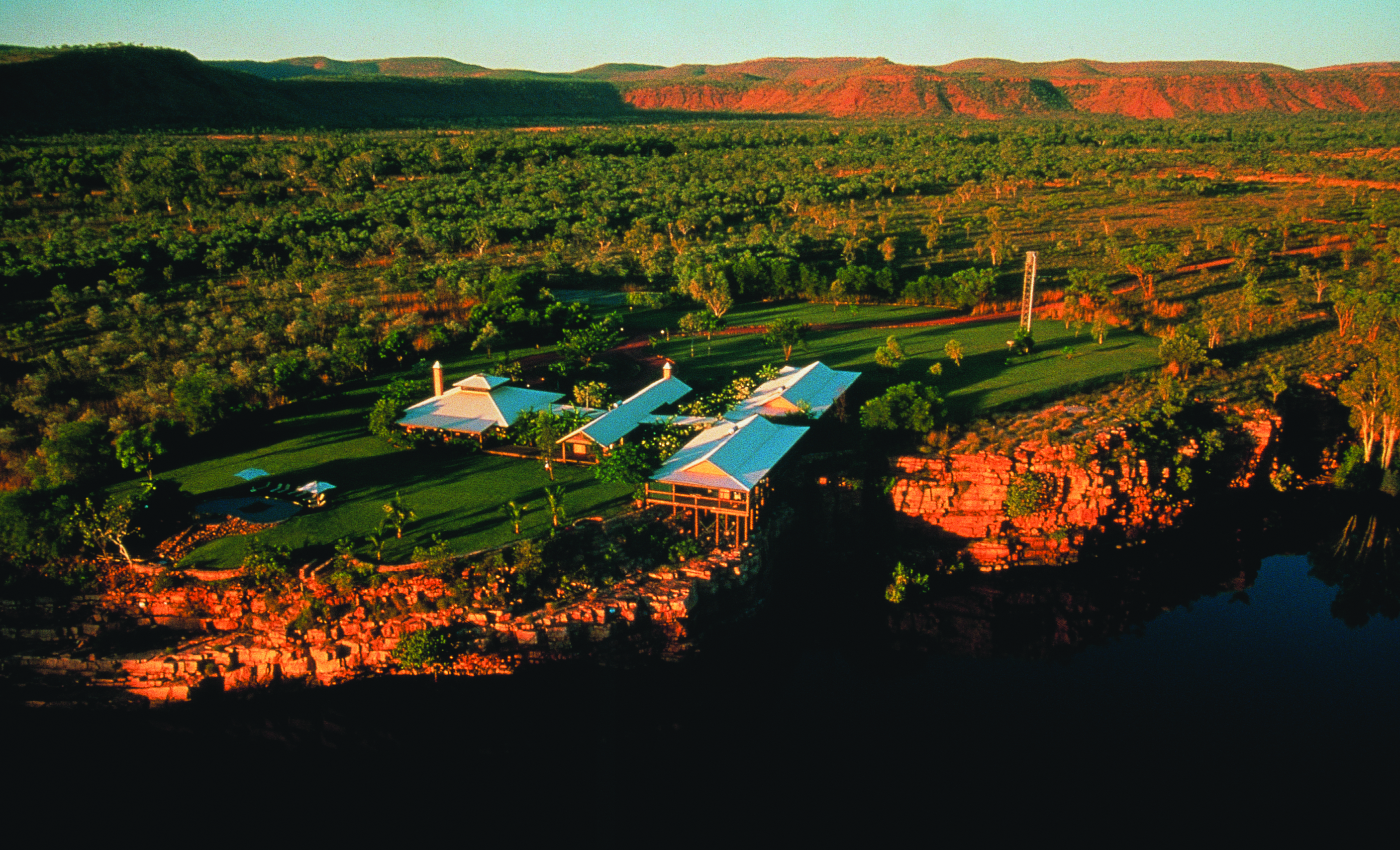 Aerial view of hotel amongst trees and rocks 