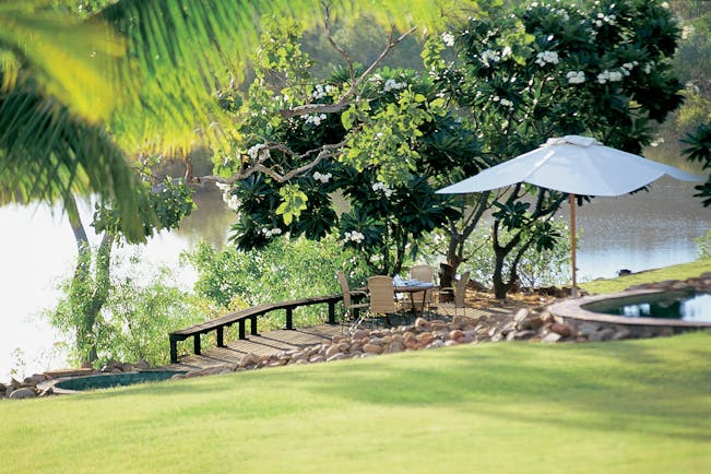 El Questro Western Australia deck lawn to decking area with seats and umbrella overlooking water