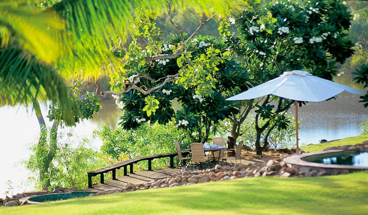 El Questro Western Australia deck lawn to decking area with seats and umbrella overlooking water