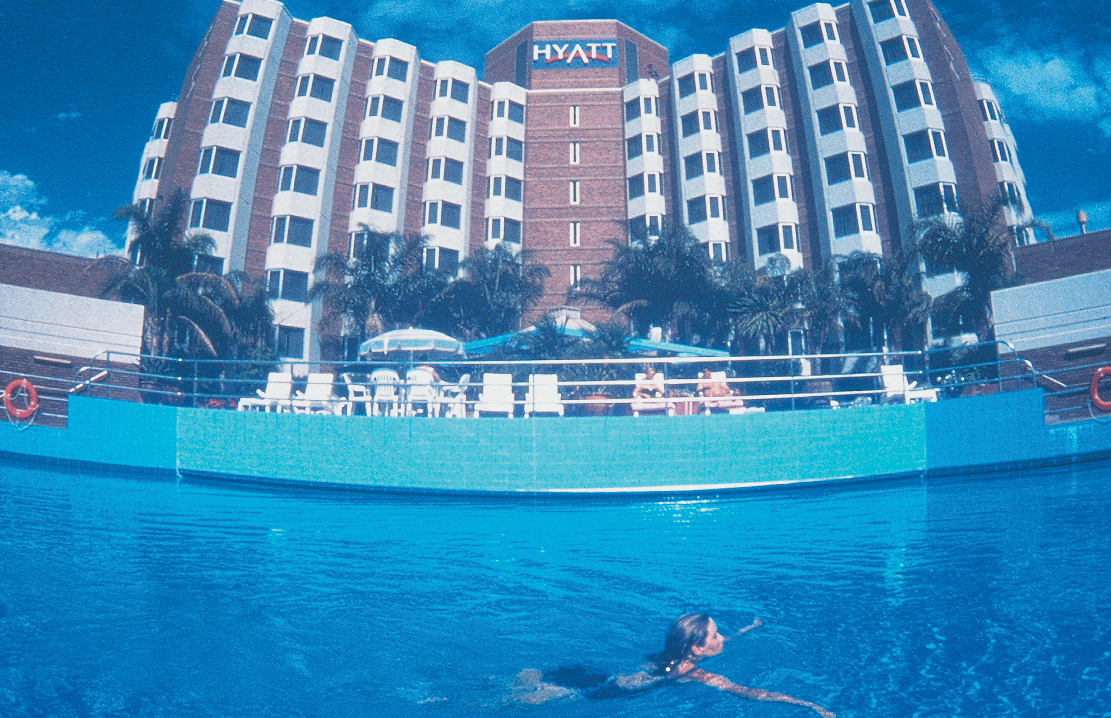 Exterior of hotel and swimming pool with building saying 