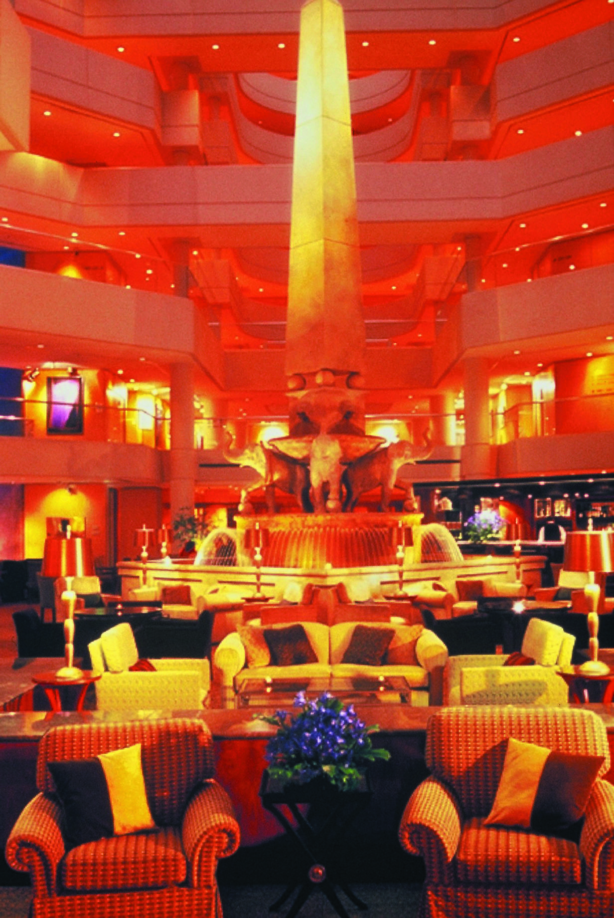 Lobby with high ceilings, arm chairs and orange lighting