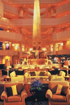 Lobby with high ceilings, arm chairs and orange lighting