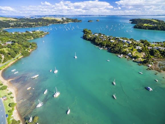 Putaki Bay in Waiheke Island near Auckland, bright blue ocean, boats on water, coastline