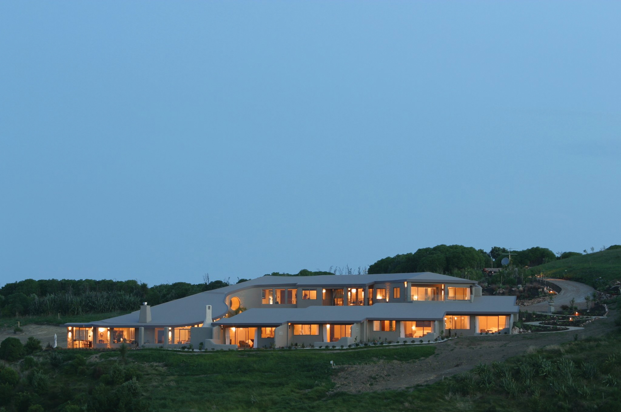 Exterior of hotel at night with white roof and window lights lighting up the hotel 