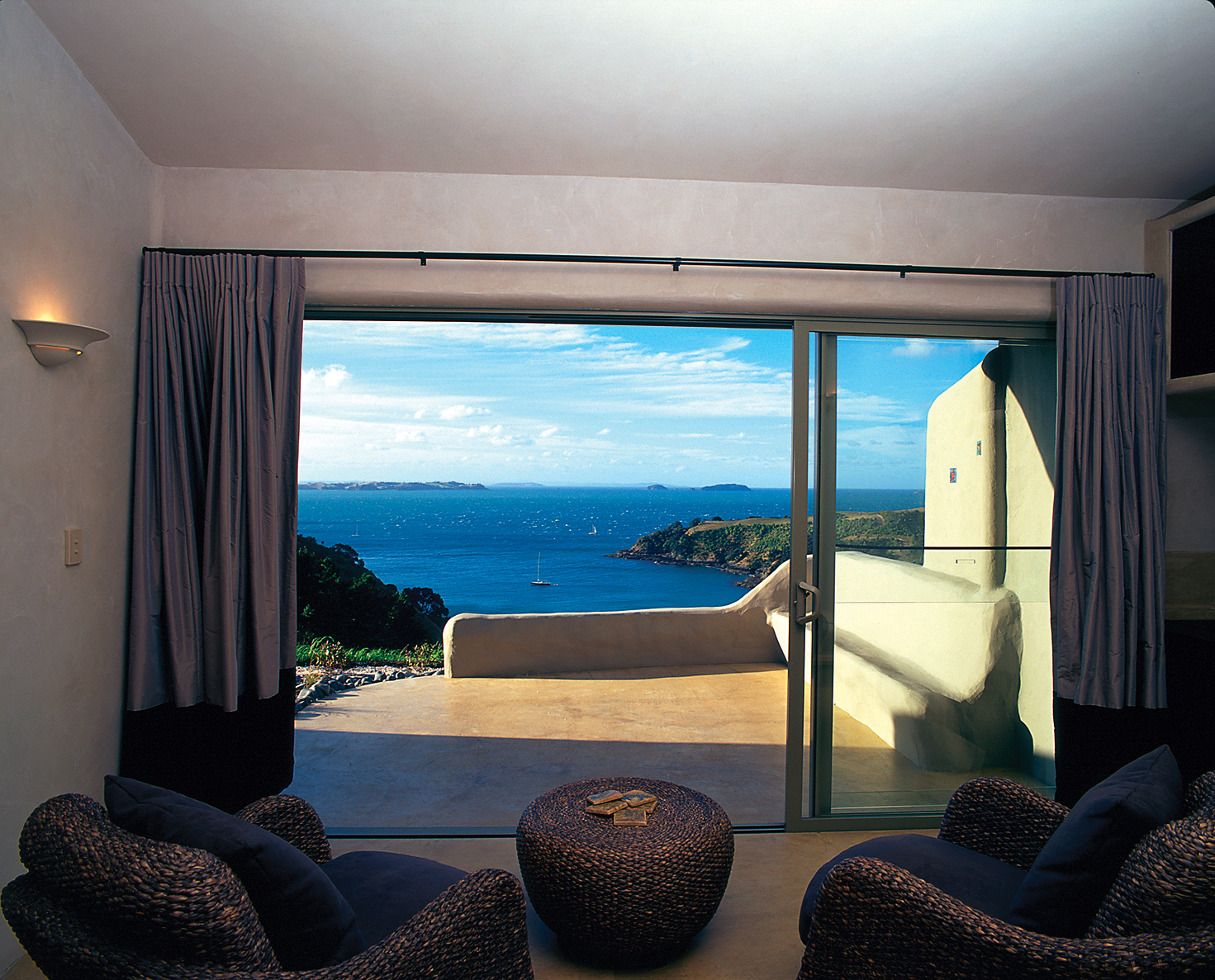 Guest room with bi-folding doors opening onto a patio looking out over the sea