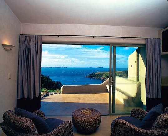 Guest room with bi-folding doors opening onto a patio looking out over the sea