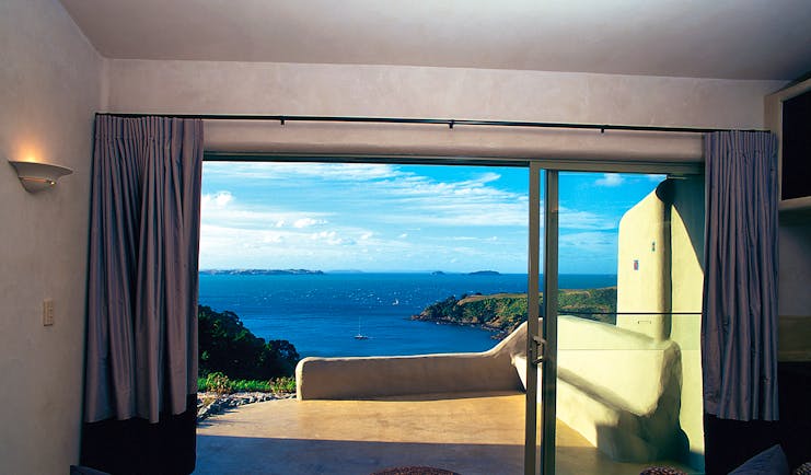 Guest room with bi-folding doors opening onto a patio looking out over the sea