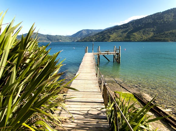 A view from the Queen Charlotte track in the Marlborough Sounds, wooden jetty, mountains, sea