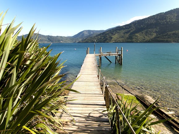 A view from the Queen Charlotte track in the Marlborough Sounds, wooden jetty, mountains, sea
