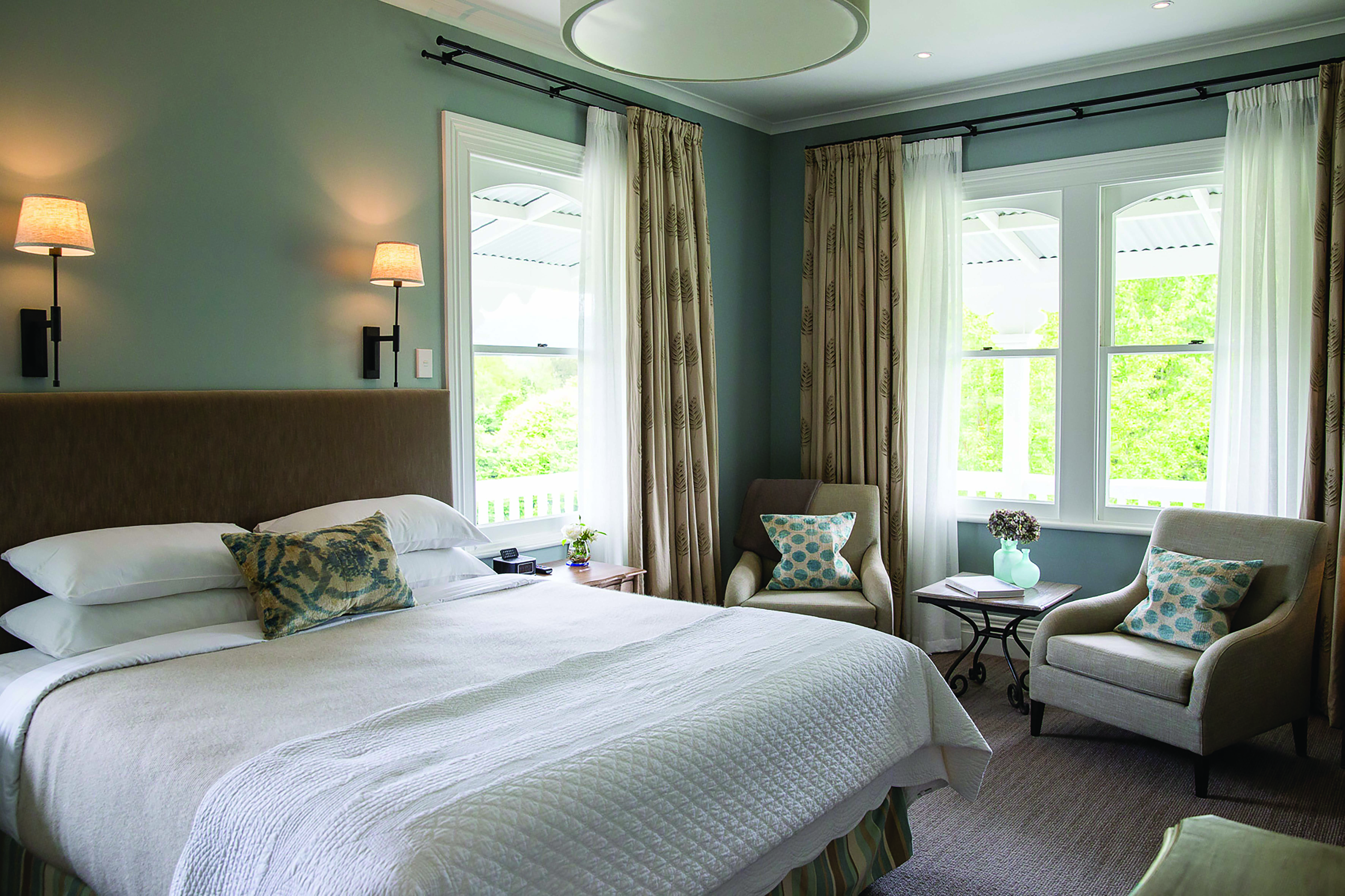 Marlborough Lodge Blenheim and Marlborough premium suite bedroom with two armchairs and porch view